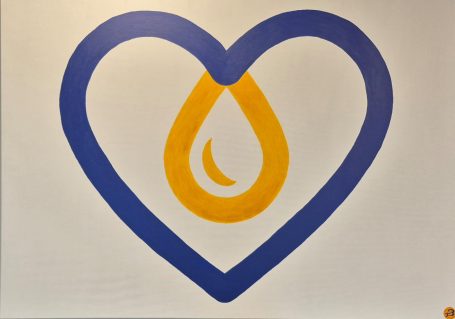 Ein herzförmiges Logo mit einer tropfenförmigen Grafik in Gelb und Blau.